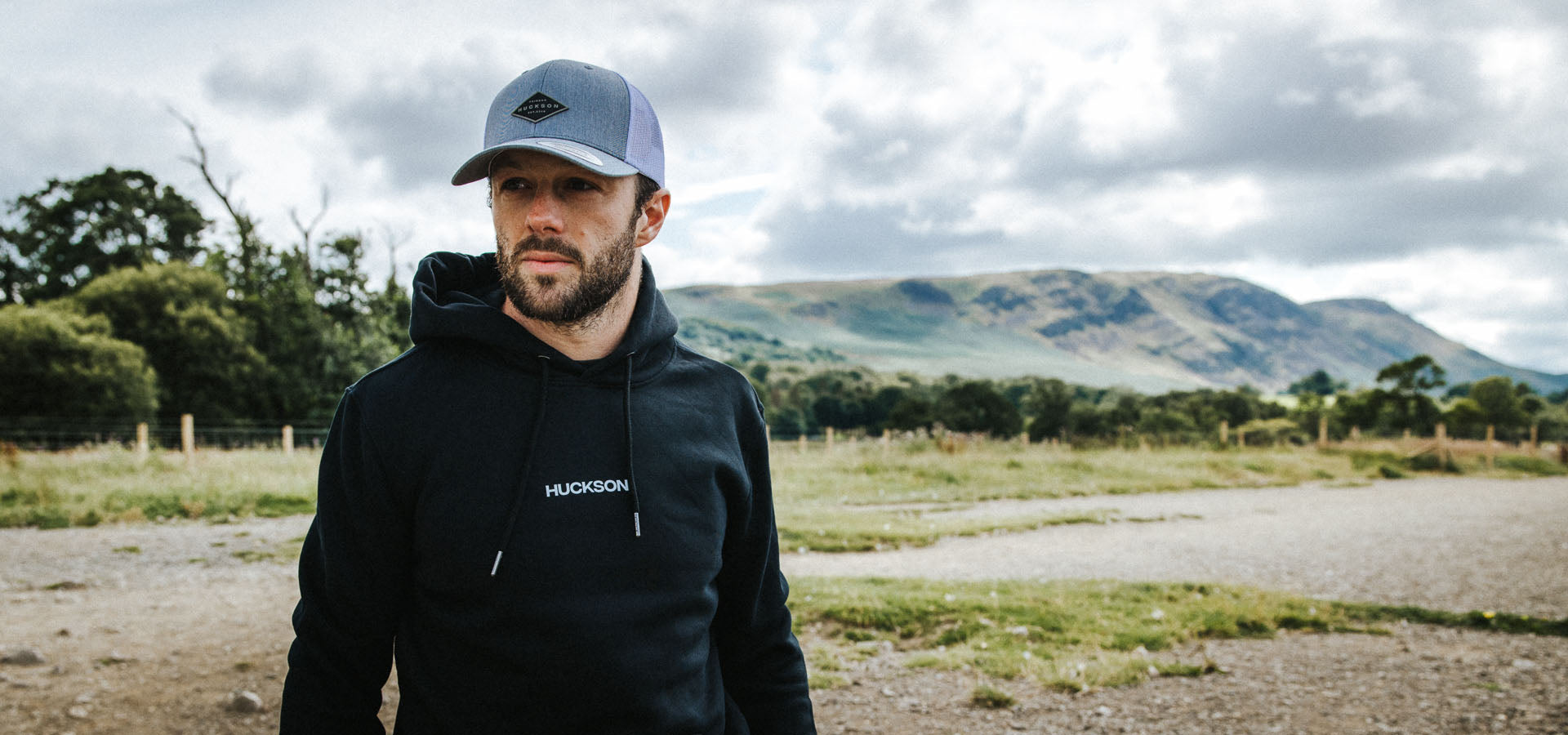 Man in hoodie with hills behind